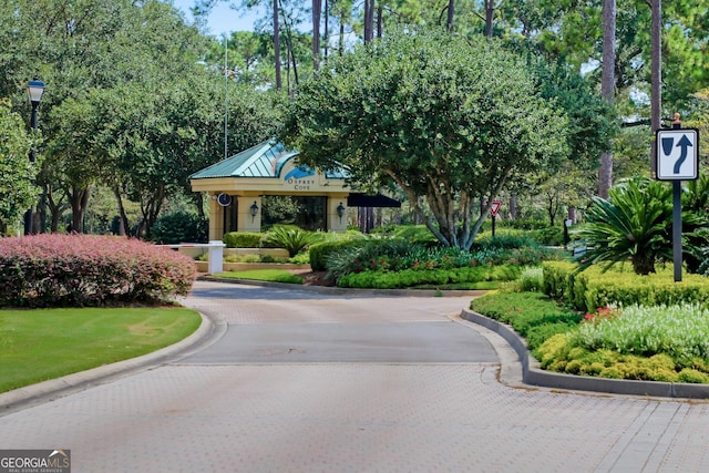 surrounding community featuring decorative driveway