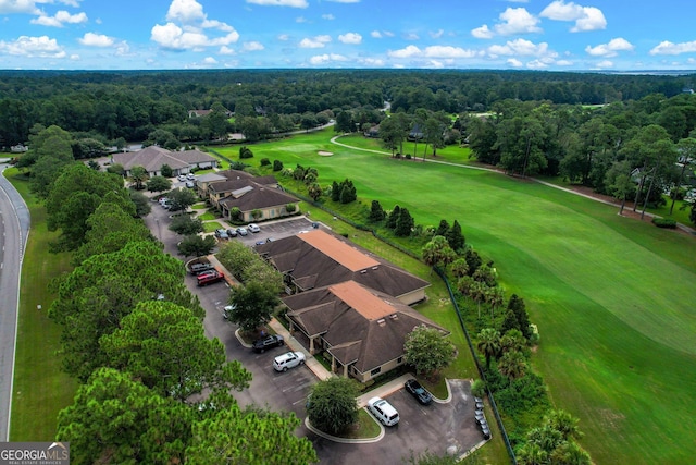 drone / aerial view featuring a view of trees and golf course view