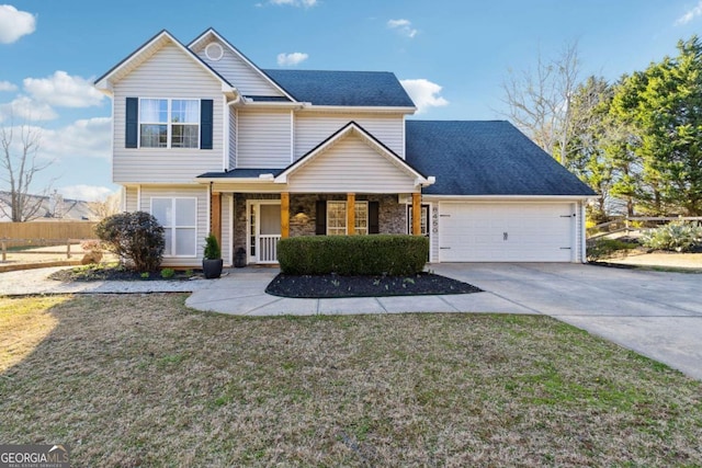 traditional home with a porch, a front yard, driveway, and an attached garage