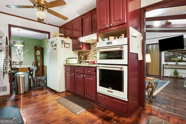 kitchen with white appliances, dark wood-style floors, reddish brown cabinets, and under cabinet range hood