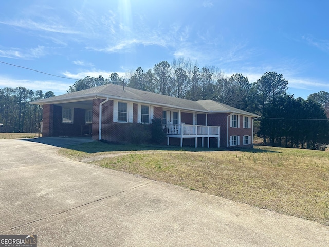 ranch-style home featuring driveway, a front yard, an attached carport, and brick siding