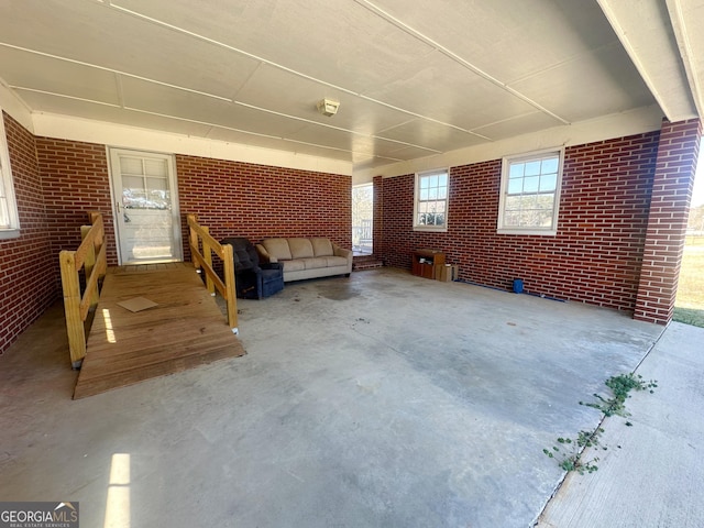 exterior space with brick wall and unfinished concrete floors