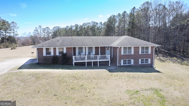 ranch-style home with a porch, a front yard, and brick siding