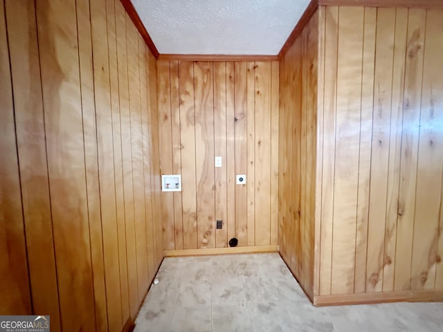 laundry room featuring a textured ceiling, wooden walls, hookup for an electric dryer, laundry area, and washer hookup