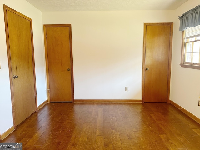 unfurnished room with baseboards and wood finished floors