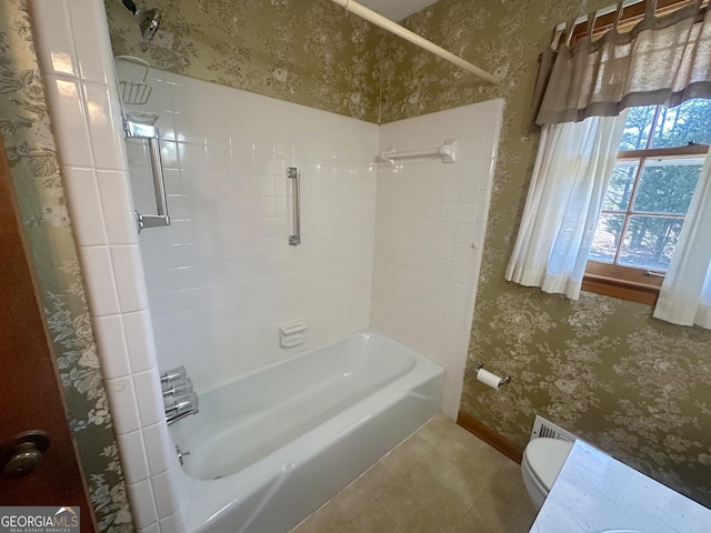 bathroom featuring toilet, wallpapered walls, and washtub / shower combination