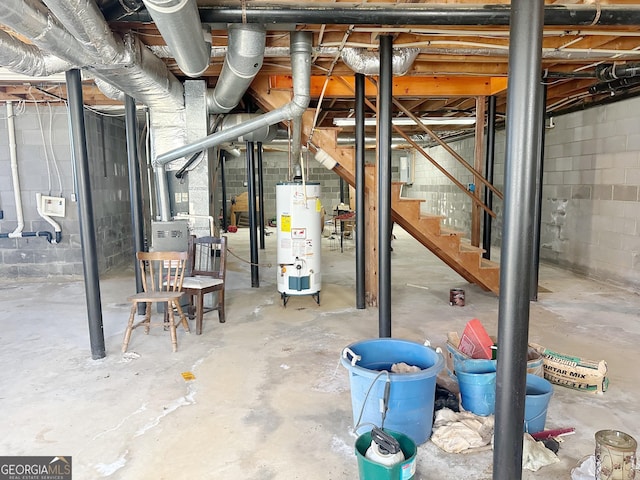 unfinished basement featuring stairs and water heater