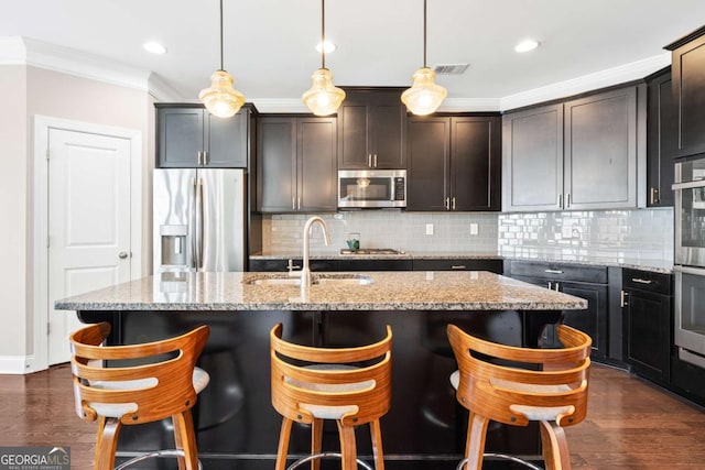 kitchen with dark wood-style flooring, stainless steel appliances, visible vents, ornamental molding, and a sink