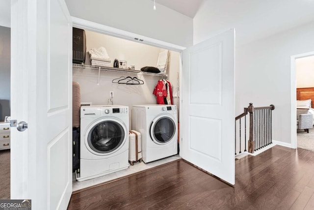 clothes washing area with laundry area, baseboards, wood finished floors, and independent washer and dryer