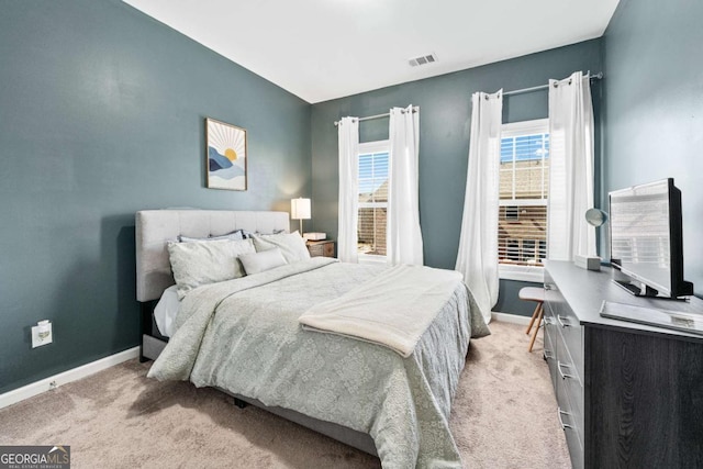 bedroom with light carpet, visible vents, and baseboards