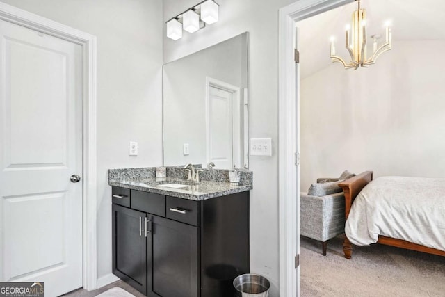 ensuite bathroom with a chandelier, ensuite bath, vanity, and baseboards