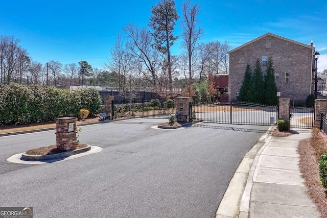 view of road featuring a gate, curbs, and a gated entry