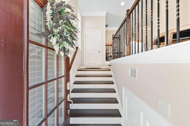 stairs with visible vents, crown molding, and recessed lighting