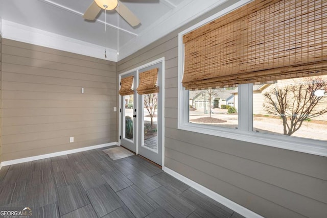 unfurnished sunroom featuring ceiling fan