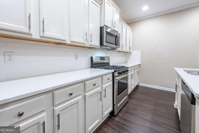 kitchen featuring white cabinetry, light countertops, appliances with stainless steel finishes, backsplash, and dark wood-style floors