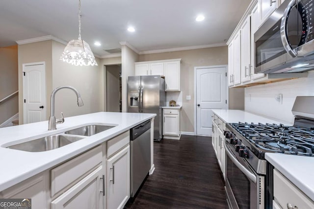 kitchen featuring dark wood finished floors, appliances with stainless steel finishes, light countertops, crown molding, and a sink