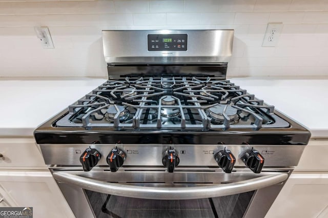 room details featuring light countertops, stainless steel gas range oven, and backsplash