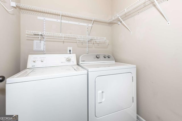 washroom featuring baseboards, laundry area, and washer and dryer