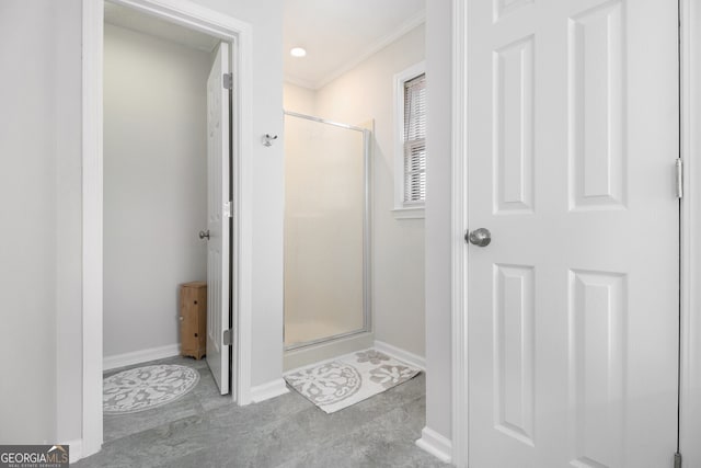 bathroom with baseboards, a shower stall, and crown molding