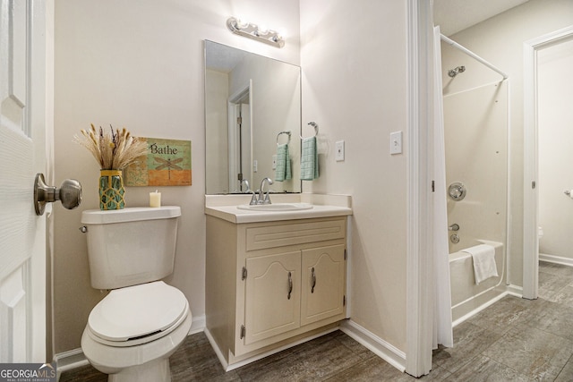 bathroom with toilet, vanity, baseboards, and shower / bathing tub combination