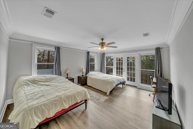 bedroom with multiple windows, visible vents, wood finished floors, and french doors