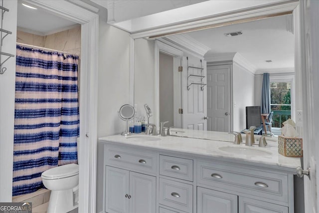 full bath with ornamental molding, a sink, toilet, and double vanity