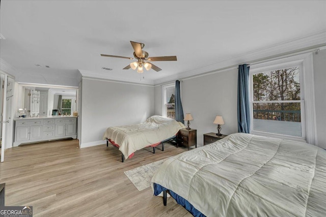 bedroom featuring light wood-style flooring, multiple windows, and ornamental molding