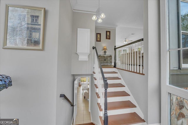 staircase with a ceiling fan and crown molding