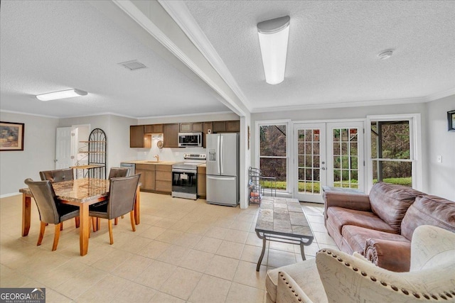 dining space featuring a textured ceiling, light tile patterned floors, visible vents, ornamental molding, and french doors