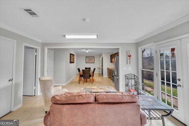 living area with light tile patterned floors, ornamental molding, a textured ceiling, and visible vents