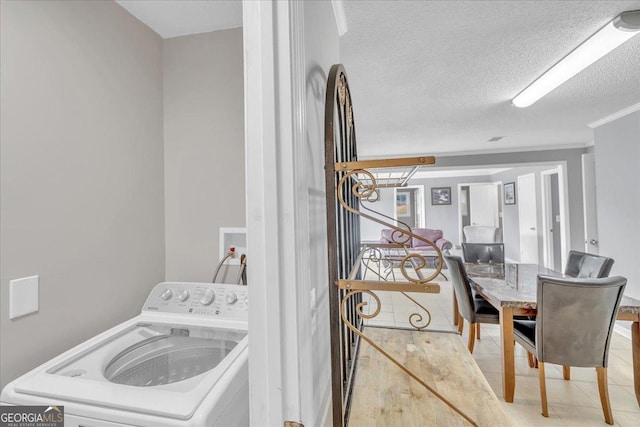 laundry room with a textured ceiling, laundry area, washer / dryer, and tile patterned floors