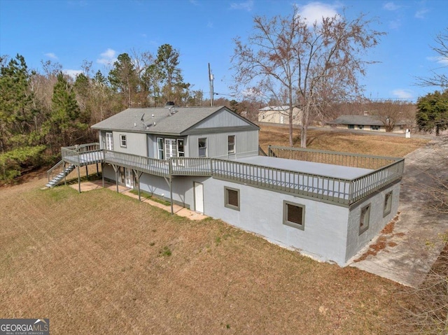 back of property featuring a yard, a wooden deck, and stairs