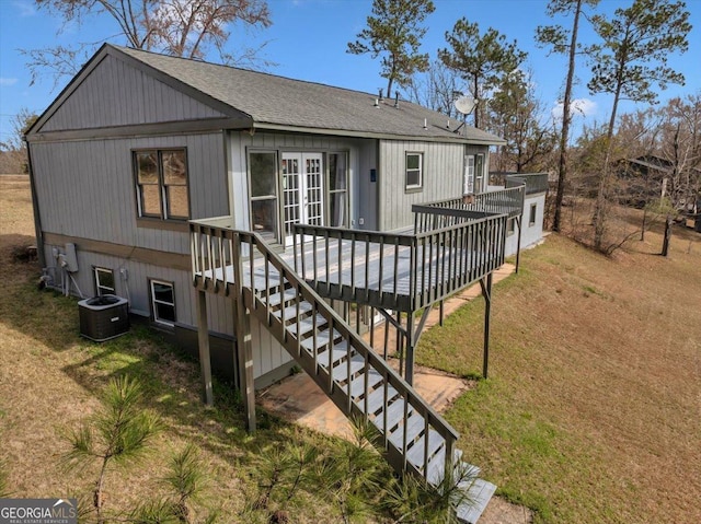 back of house with a shingled roof, stairway, cooling unit, and a yard