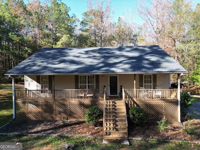 view of front facade featuring stairs, a shingled roof, and covered porch