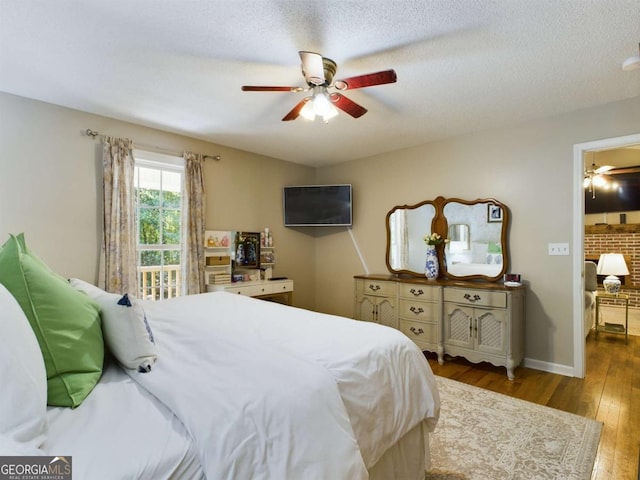 bedroom featuring ceiling fan, a textured ceiling, baseboards, and hardwood / wood-style flooring