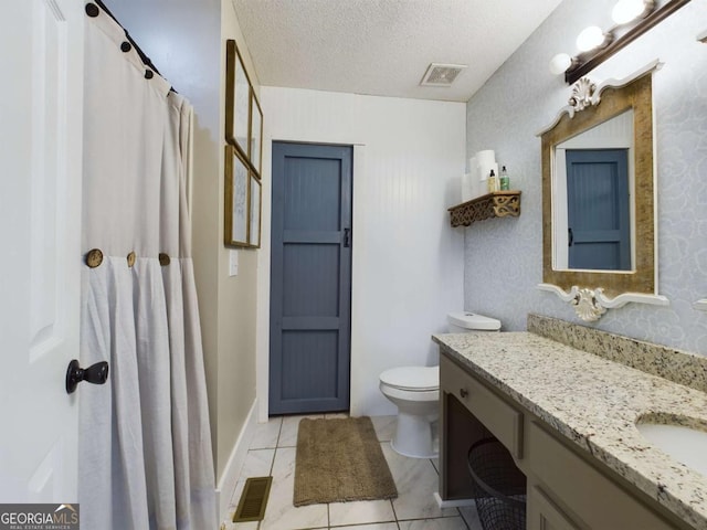 bathroom with toilet, visible vents, a textured ceiling, and vanity