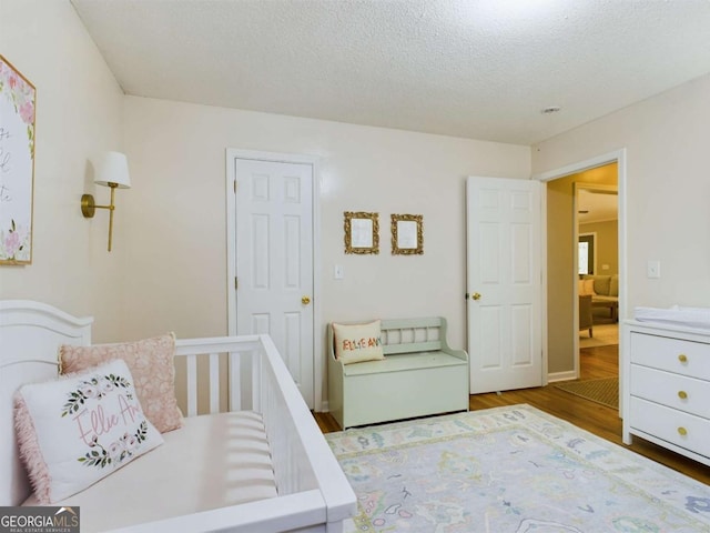 bedroom featuring a textured ceiling and wood finished floors