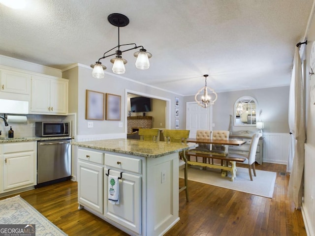 kitchen with stainless steel appliances, a sink, dark wood finished floors, and white cabinetry