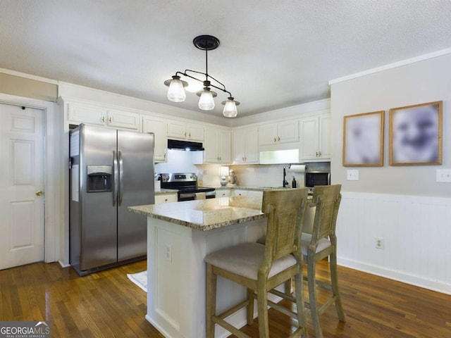 kitchen with under cabinet range hood, white cabinetry, dark wood-style floors, and appliances with stainless steel finishes