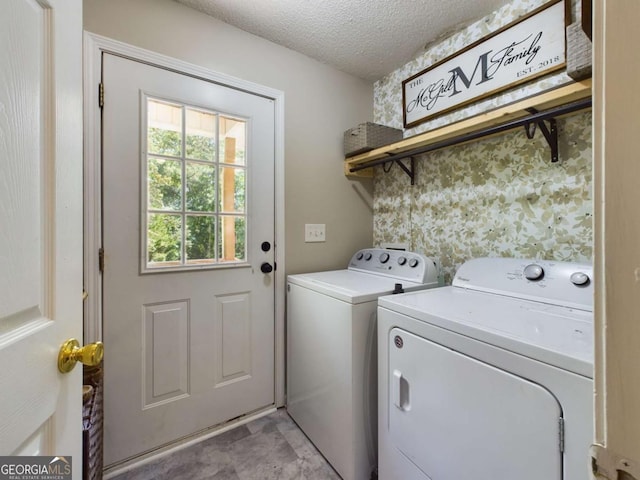 clothes washing area with laundry area, wallpapered walls, a textured ceiling, and washing machine and clothes dryer