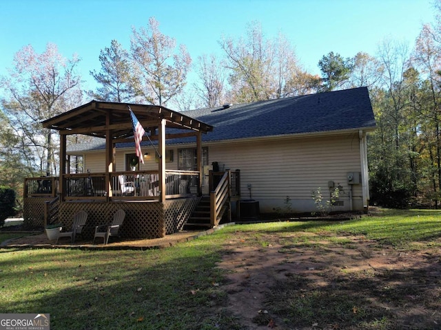 back of house with a deck, a yard, a shingled roof, and cooling unit