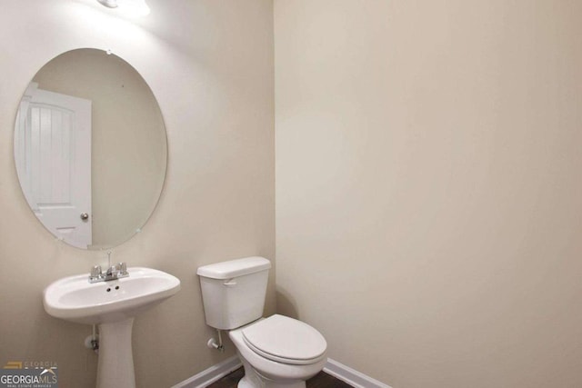 bathroom with toilet and baseboards