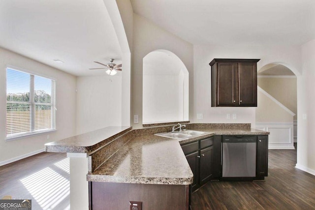 kitchen with dark brown cabinets, stainless steel dishwasher, dark wood-style flooring, and a sink