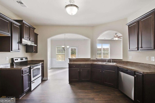 kitchen featuring dark countertops, dark brown cabinetry, stainless steel appliances, and a sink