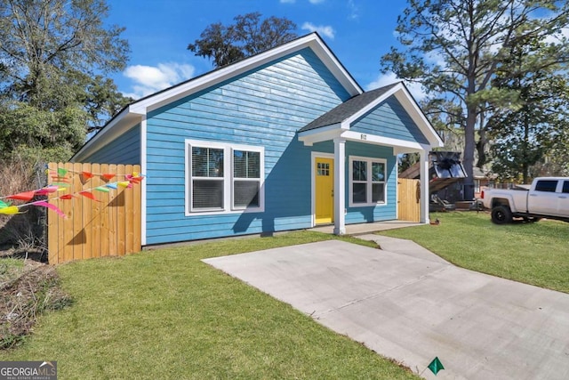 view of front of home featuring fence and a front lawn