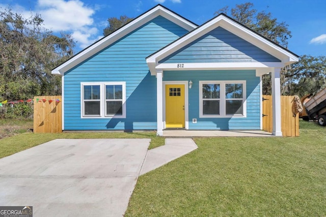 bungalow-style house featuring fence and a front lawn