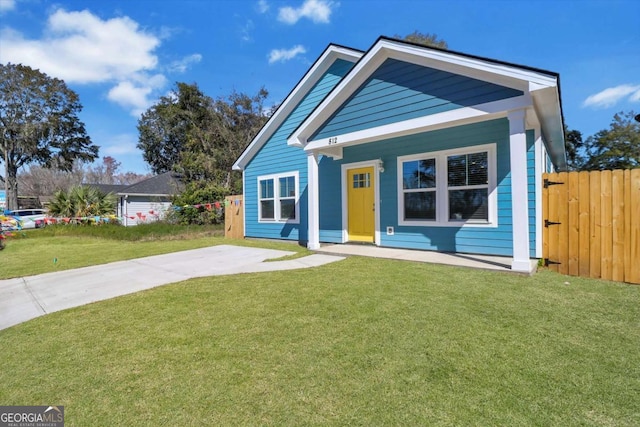 view of front of home with fence and a front lawn