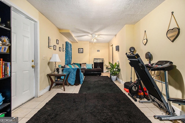 interior space with a ceiling fan, baseboards, and a textured ceiling