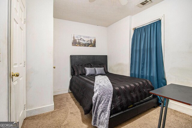 carpeted bedroom with a textured ceiling, baseboards, and visible vents