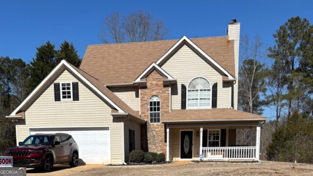 traditional-style home with stone siding, covered porch, a chimney, and a garage